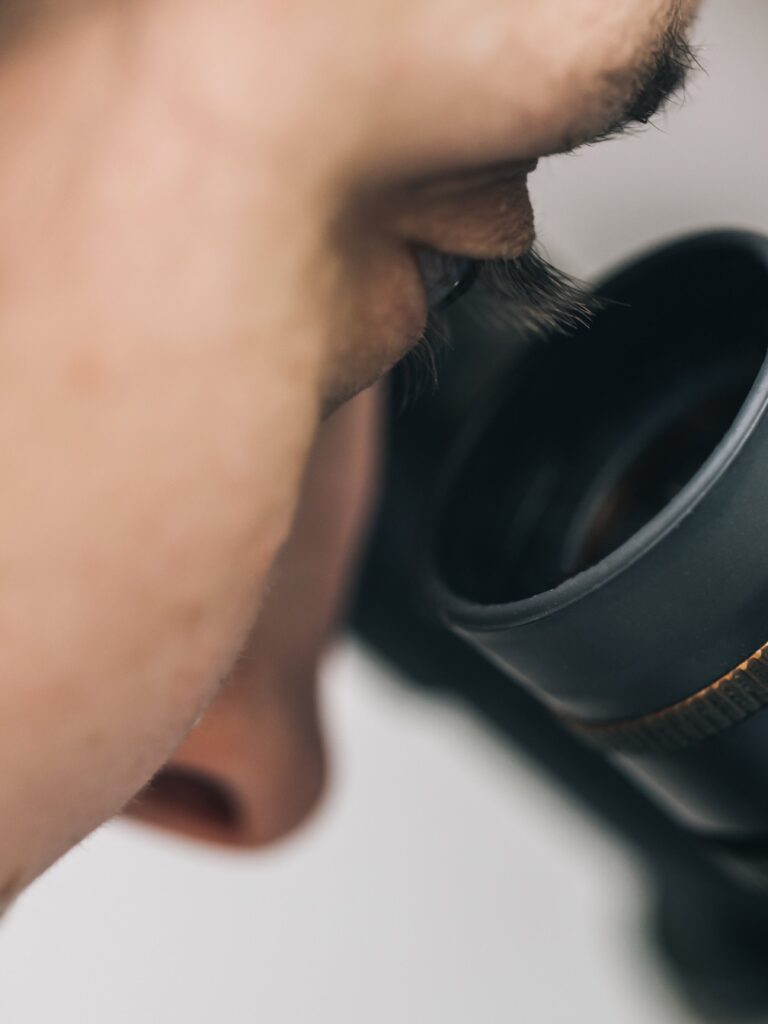 Person Looking Through Magnifying Glass